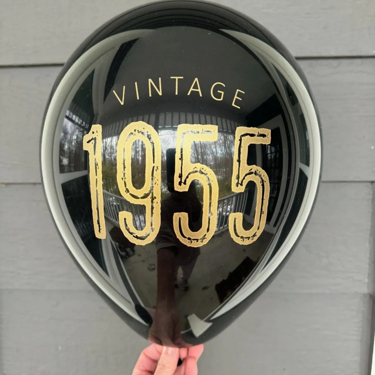 12 inch black latex balloon that reads Vintage 1955 in a gold metallic ink. 70th birthday balloon