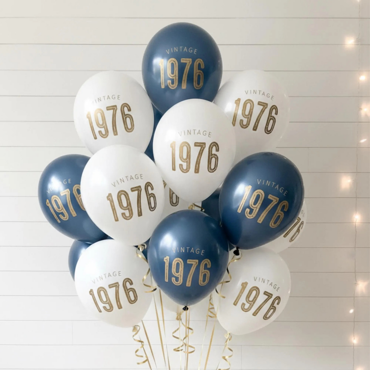 50th Birthday balloons.  A balloon bouquet of navy and white balloons that read Vintage 1976 in bold gold font.  Perfect 50th Birthday Decor for a milestone celebration