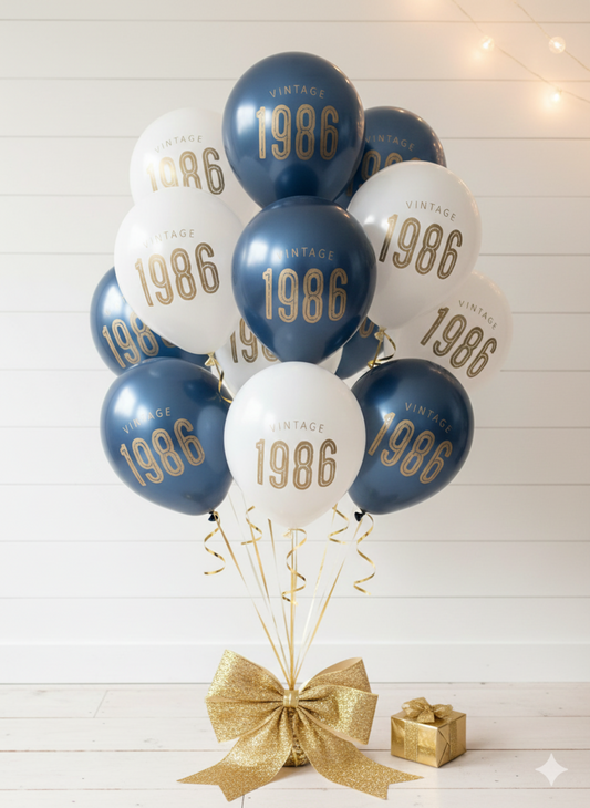 Balloons with '1986' printed on them, tied together with a gold ribbon on a white wooden background.