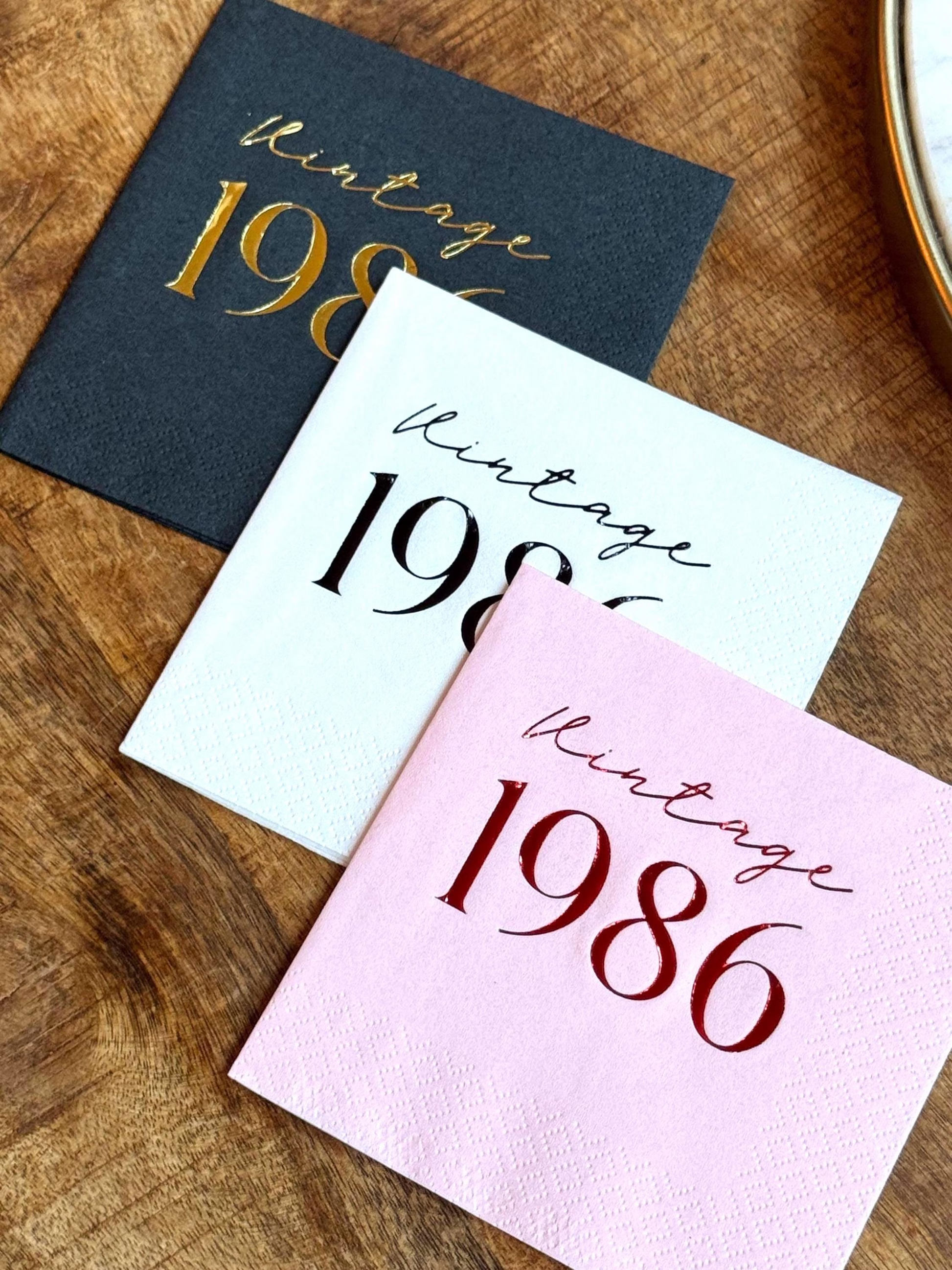 Three napkins with 'Vintage 1986' text on a wooden surface