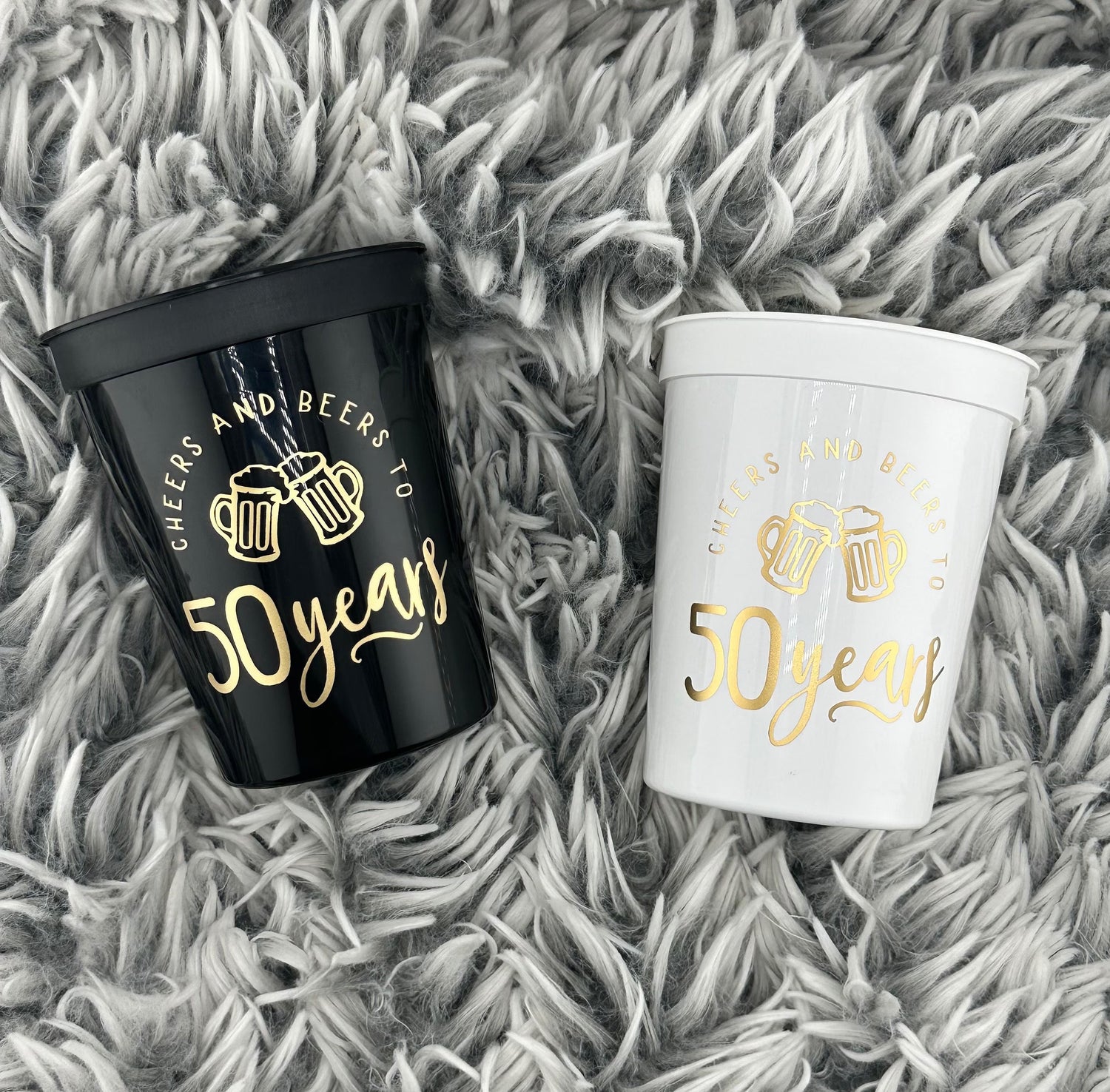 Black and white stadium cups that read cheers and beers to 50 years in gold metallic font.  50th Birthday or Milestone cups.