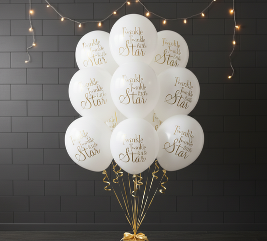 White balloons with gold text 'Twinkle twinkle little star' on a dark brick wall background.