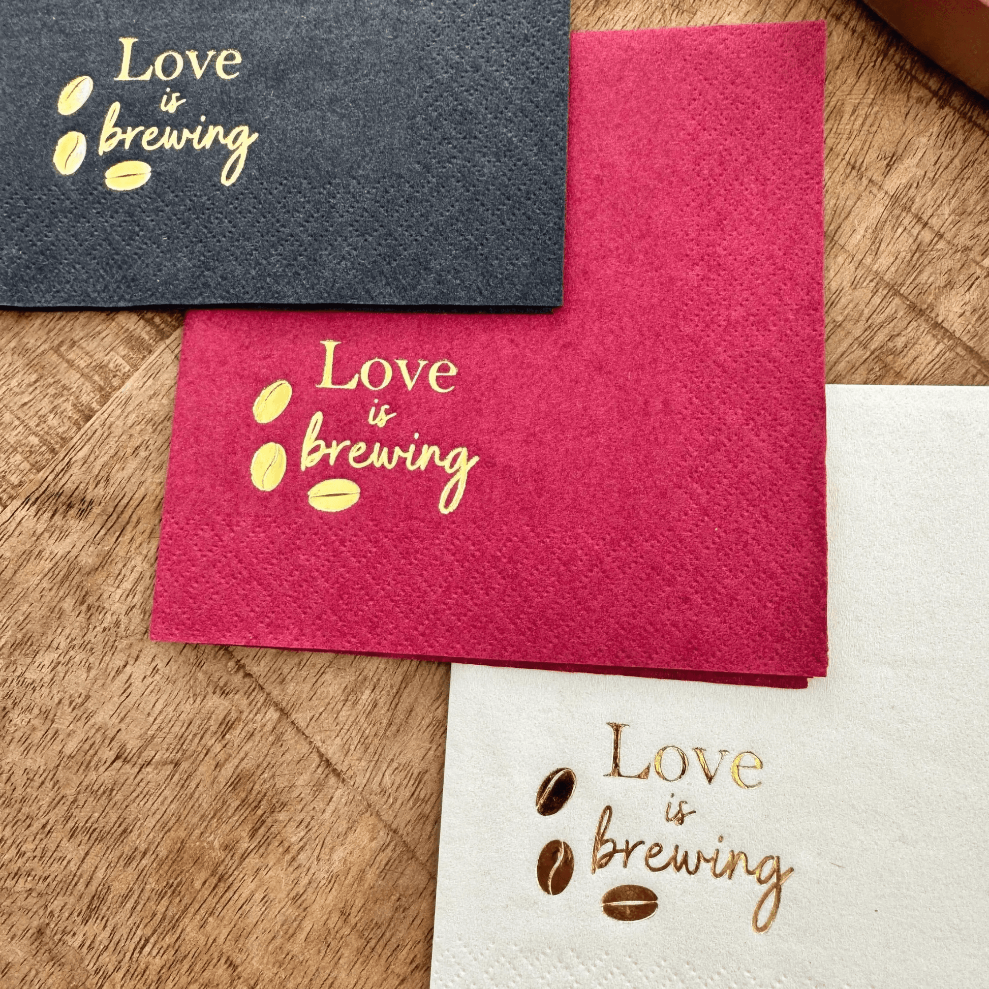 Love is brewing cocktail napkins stamped in a gold foil with coffee beans
