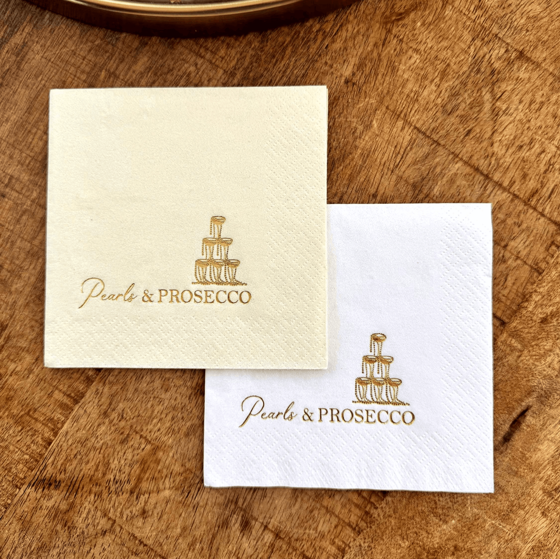 Pearls and Prosecco Cocktail napkins that are stamped in a gold foil with a champagne tower with pearl necklaces