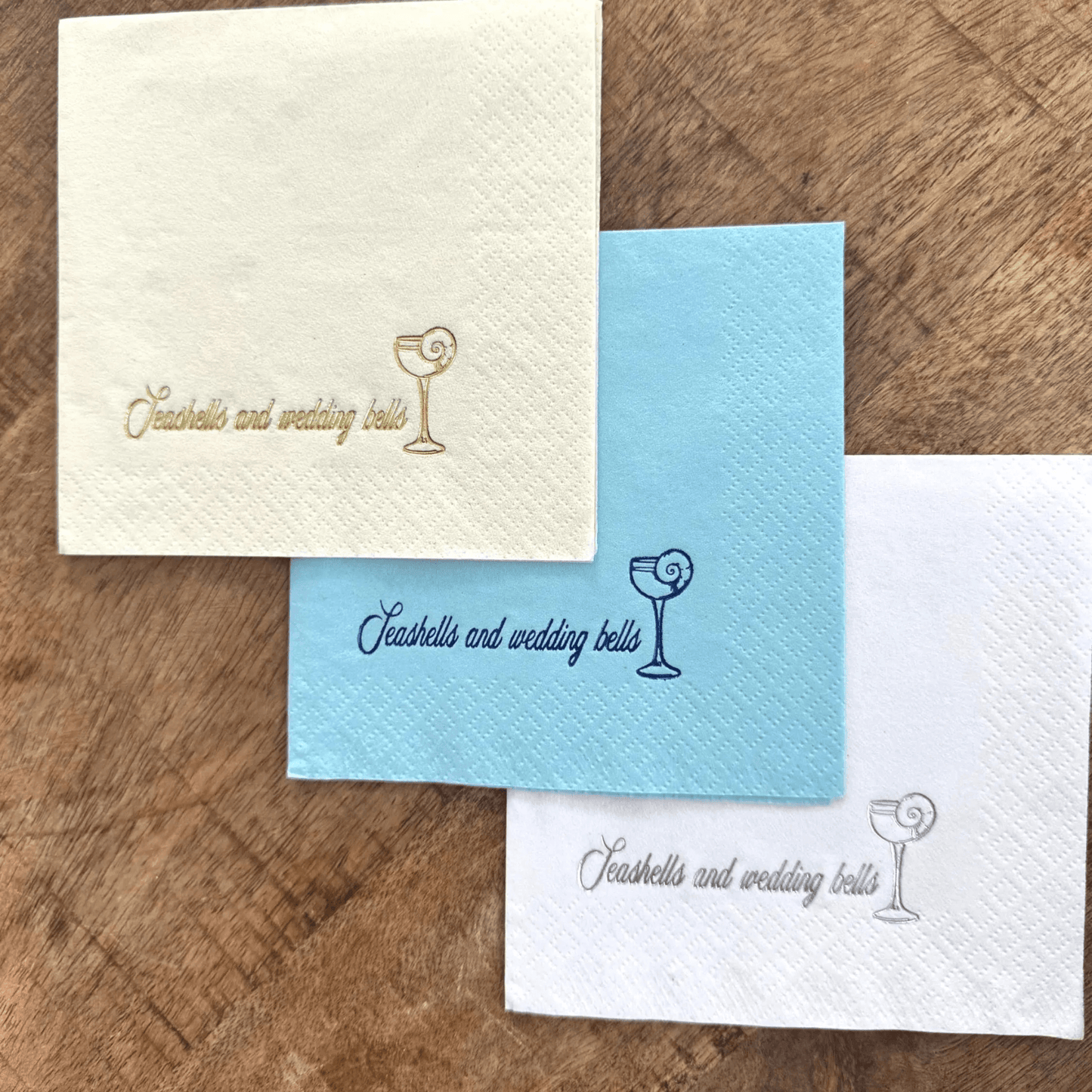 Cocktail Napkins that are foil stamped and read Seashells and Wedding Bells.  Coastal Bridal Shower Table Decor