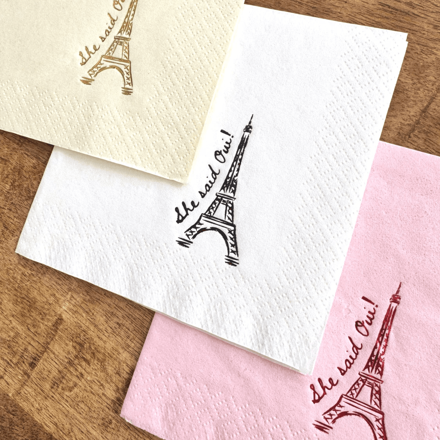 She Said Oui cocktail napkins featuring Eiffel Tower design in pink, yellow, and white for Parisian-themed events.