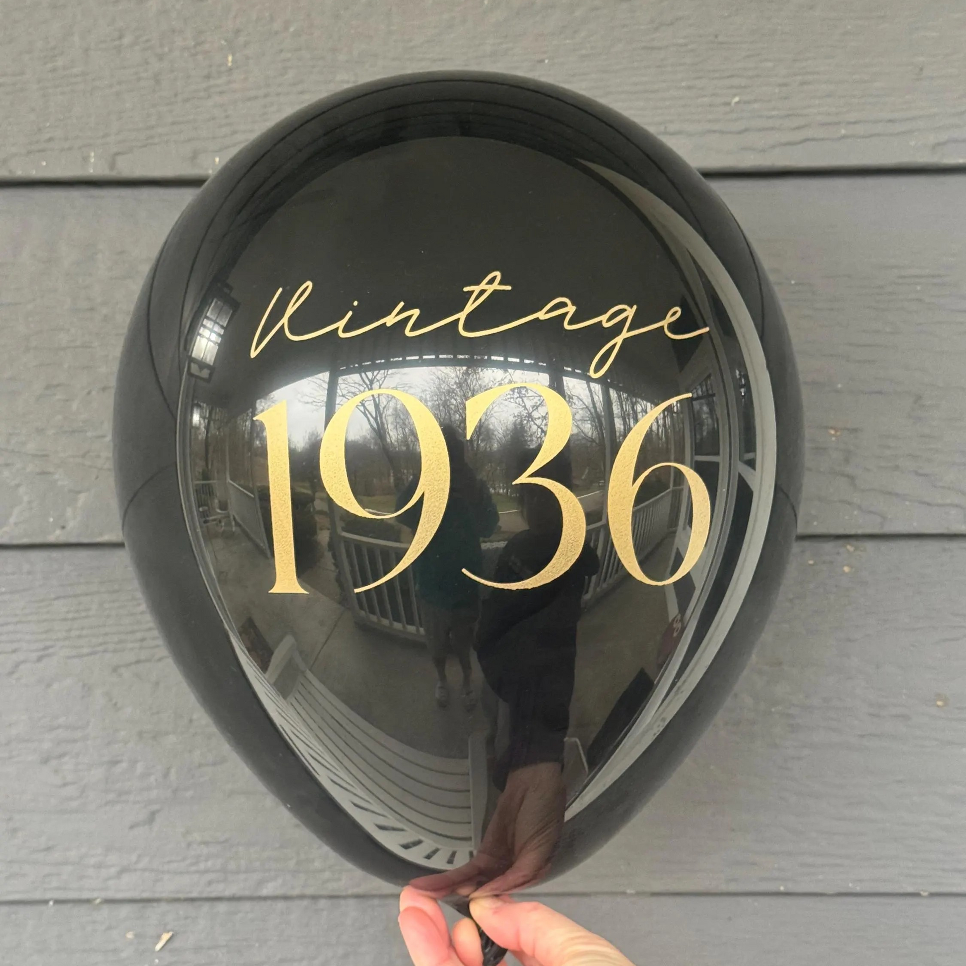 Black Latex Balloon that reads vintage 1936 in gold font