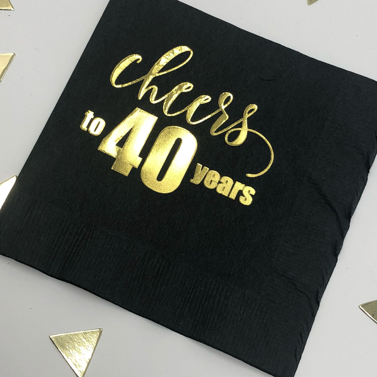 black cocktail napkin that reads Cheers to 40 years, stamped in gold foil.
40th Milestone Napkin