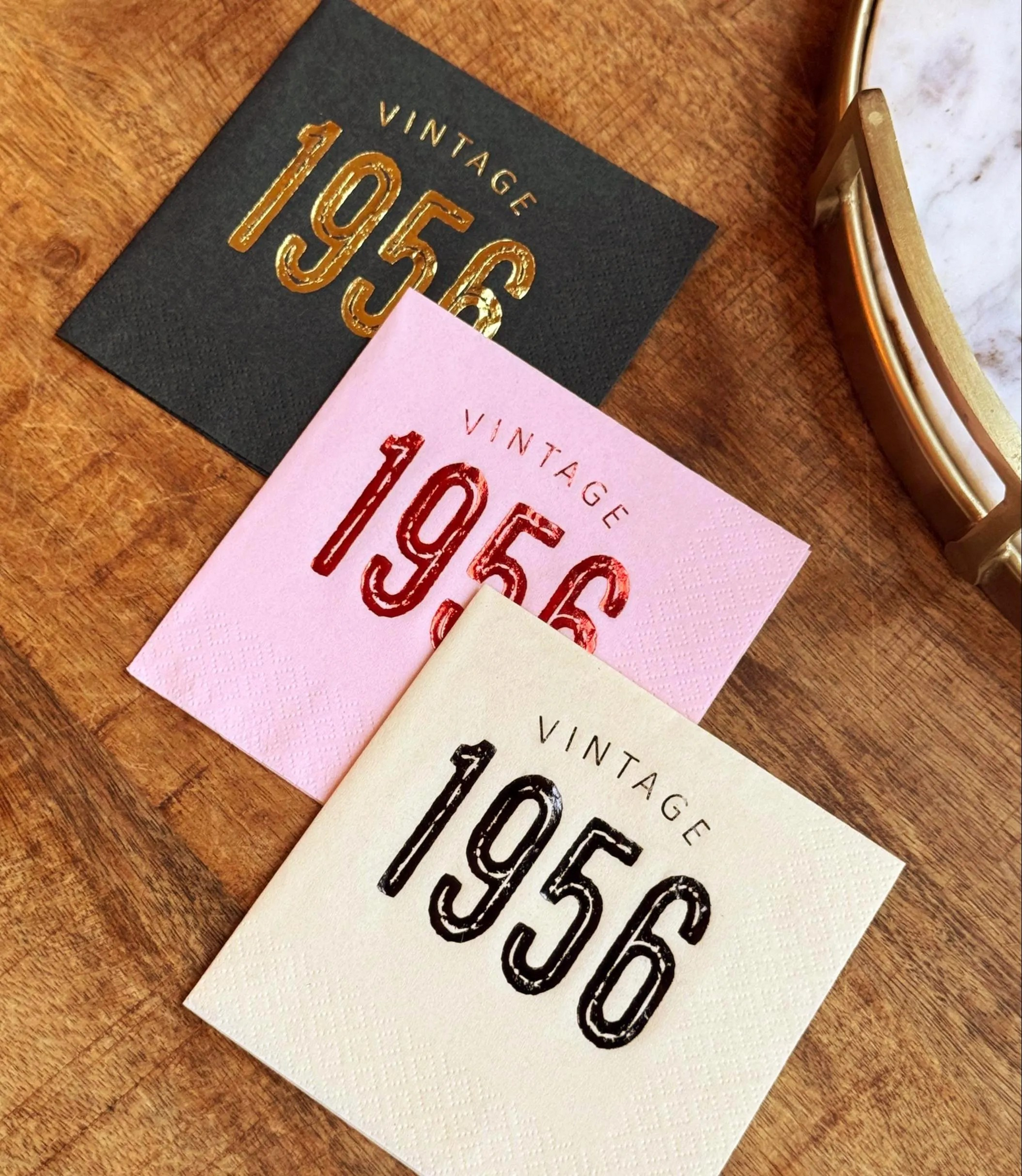 Three vintage-themed cocktail napkins with 'Vintage 1956'  stamped in foil