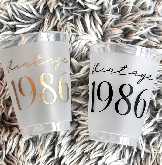 Two Vintage 1986 frosted flex cups 16 ounce in a gold and a black font.