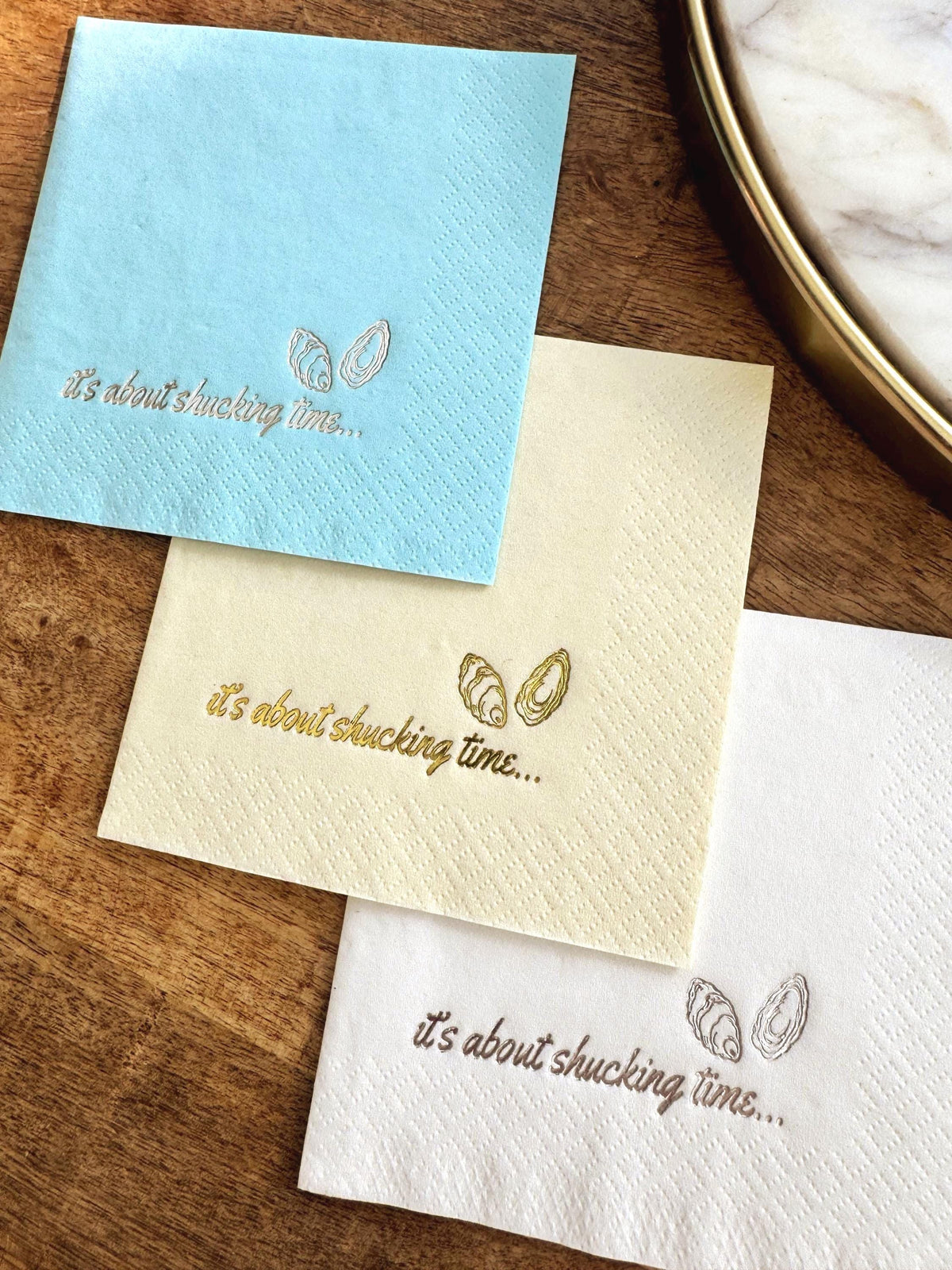 Foil Stamped Cocktail Napkins that read It's about shucking time with oyster shells.  Coastal Bachelorette Party