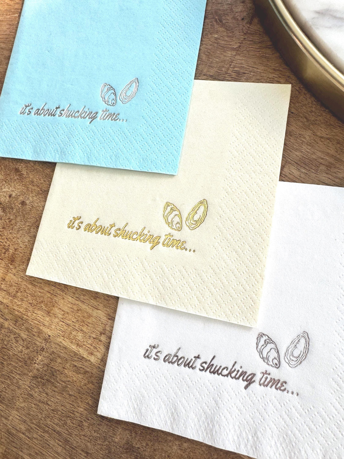 Foil Stamped Cocktail Napkins that read It's about shucking time with oyster shells.  Nautical Engagement Party Decor