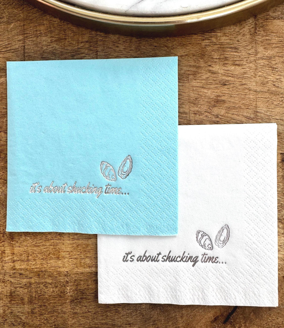 Foil Stamped Cocktail Napkins that read It's about shucking time with oyster shells.  Coastal Napkin Party Decor