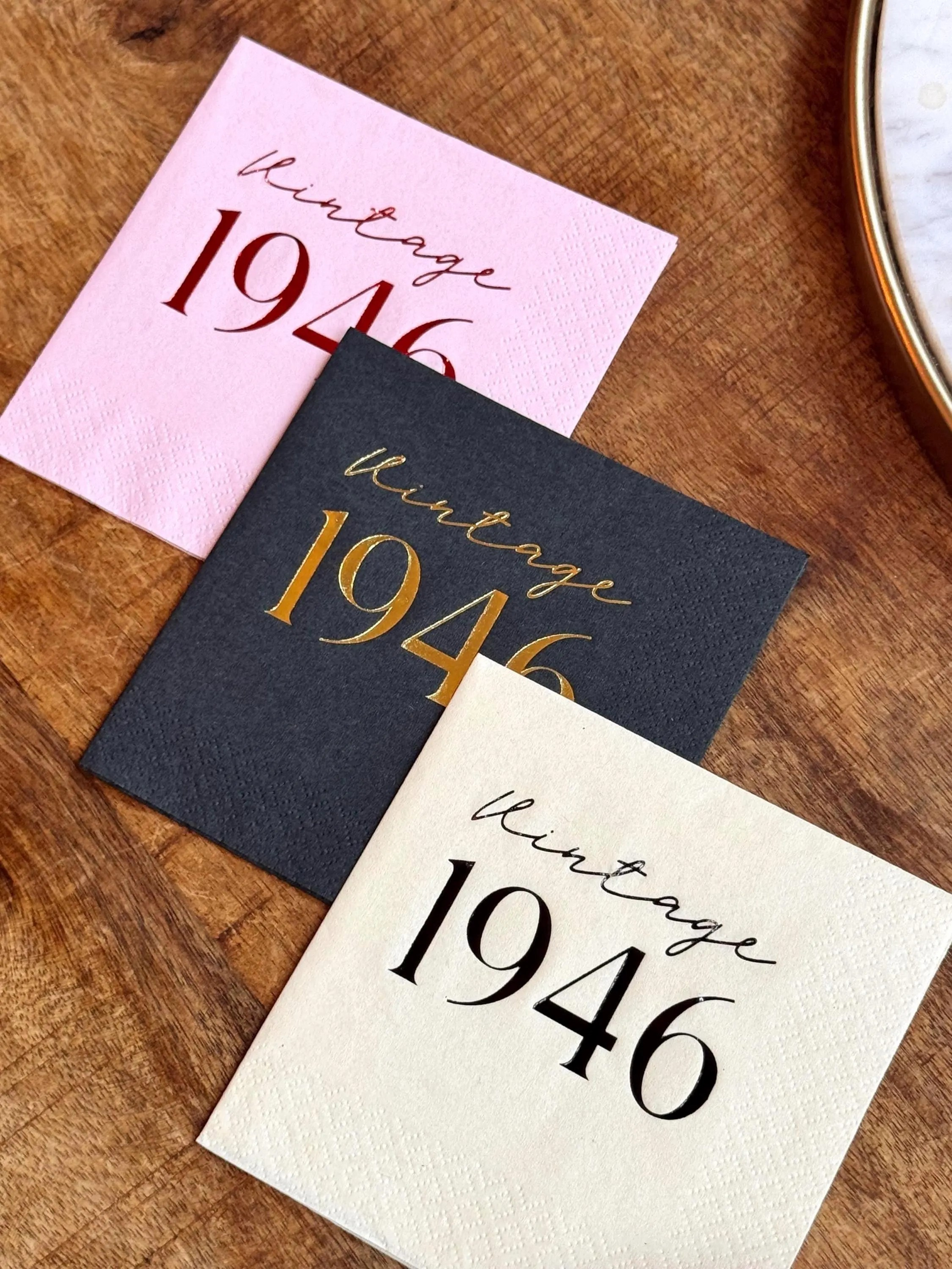 Three napkins with 'Vintage 1946' text on a wooden surface