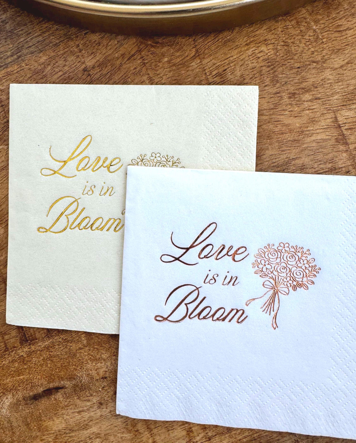 Elegant floral cocktail napkins with “Love Is in Bloom” lettering and bouquet design