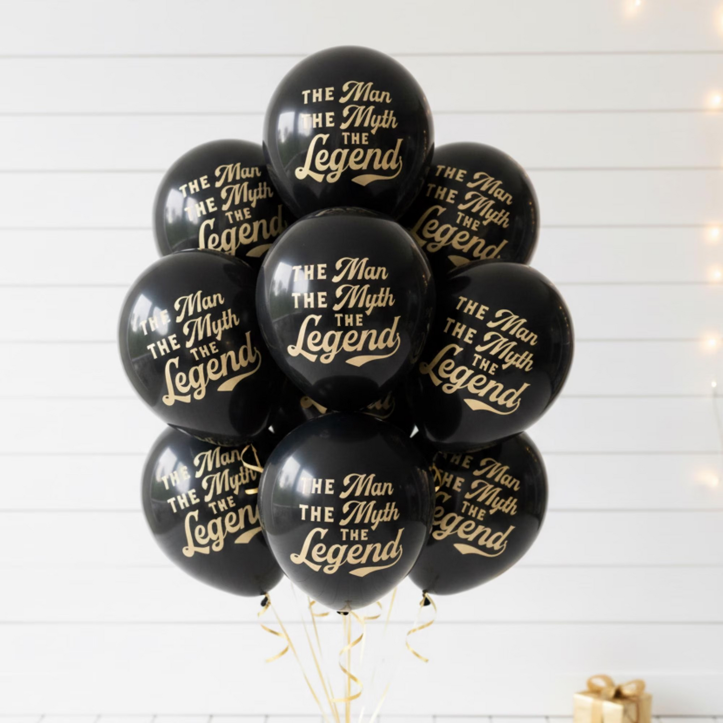 A balloon bouquet with black balloons that read The Man They Myth The Legend in a gold font.  Retirement or Milestone balloons for a guy.