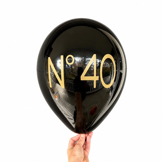 Black No 40 latex birthday balloon with gold lettering against a white background.