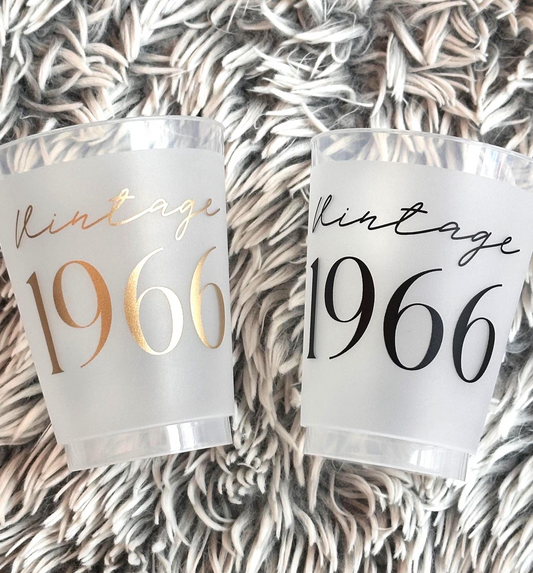 Two frosted flex glasses with 'Vintage 1966' text on a textured surface in black and gold metallic ink.